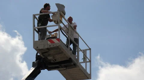 Workers on an aerial platform on a blue sky background in Paris Stock Footage 56822732