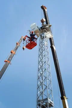 Workers on aerial platform with the help of a crane carry out the installation Stock Photos