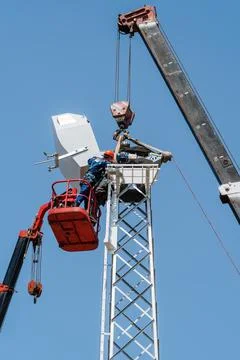 Workers on aerial platform with help of crane carry out installation Stock Photos
