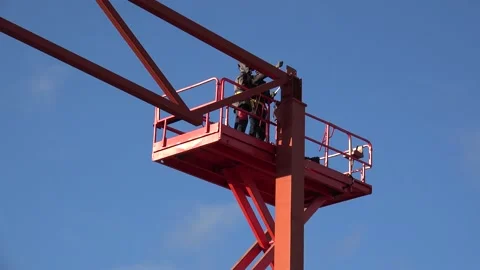 Workers on the aerial work platform are securing the metal structure with bolts. Vídeos de archivo 234396178