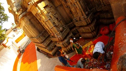 Workers and children take things from pile with prasad near walls with statues o Stock Footage 99280253