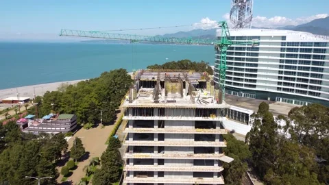 Workers and cranes on seaside construction Stock Footage 168626780