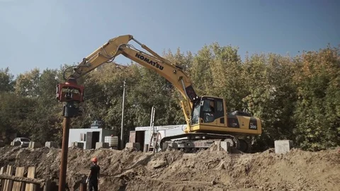 Workers and excavator on a construction site pile driving into the ground Stock Footage 71219164