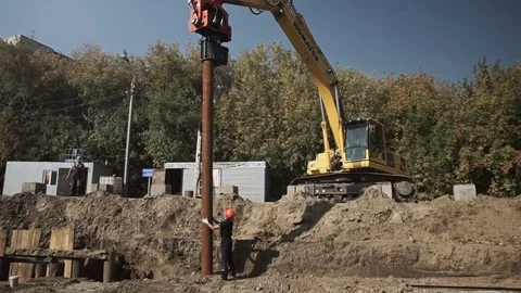 Workers and excavator on a construction site pile driving into the ground Stock Footage 71219247