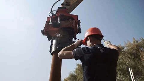 Workers and excavator on a construction site pile driving into the ground Stock Footage 71219254