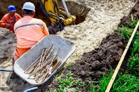 Workers and excavator is digging on building site Stock Photos