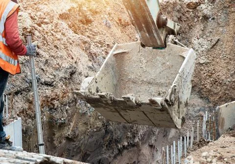 Workers and large machinery working at construction sites Stock Photos