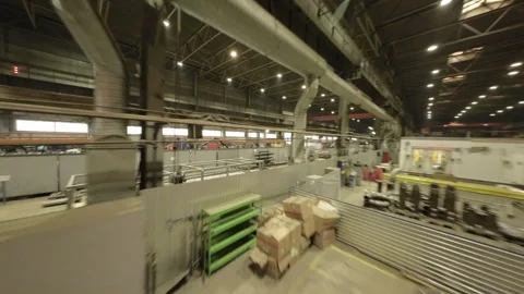 Workers and machines fill expansive production hall Stockbeeldmateriaal 304415004