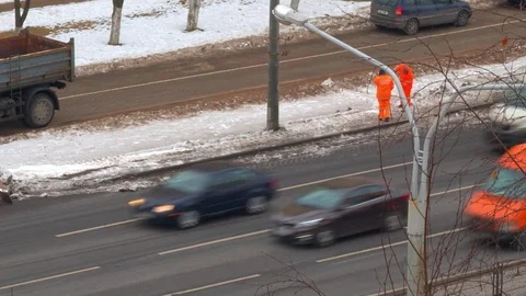 Workers and a tractor to clear snow on the street Stock Footage 72574968