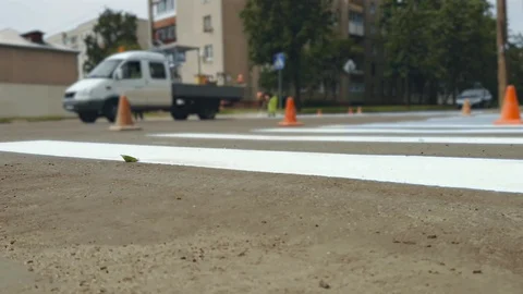 Workers apply by paint horizontal road marking zebra for Pedestrian crossing on Stock Footage 120833321