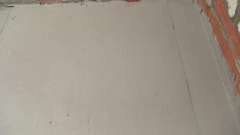 Workers applying self-leveling concrete on construction site floor Stock Photos