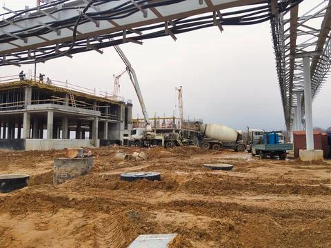 Workers are actively engaged in constructing a large building amidst a busy c Stock-Fotos