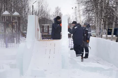Workers are assembling ice blocks on the frame of a wooden slide 写真素材