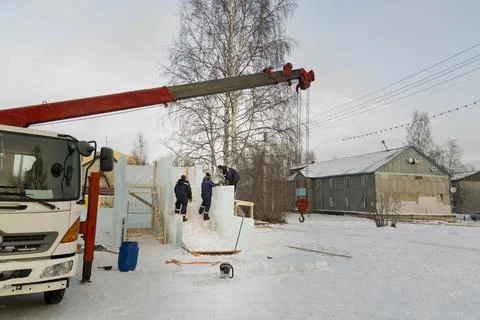 Workers are assembling ice blocks on the frame of a wooden slide 스톡 사진
