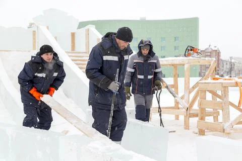Workers are assembling ice blocks on the frame of a wooden slide 스톡 사진