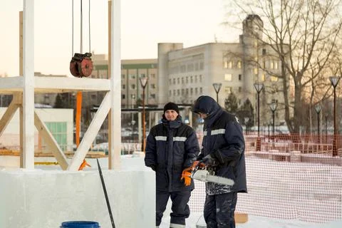 Workers are assembling ice blocks on the frame of a wooden slide 스톡 사진