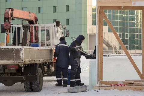 Workers are assembling ice blocks on the frame of a wooden slide 스톡 사진