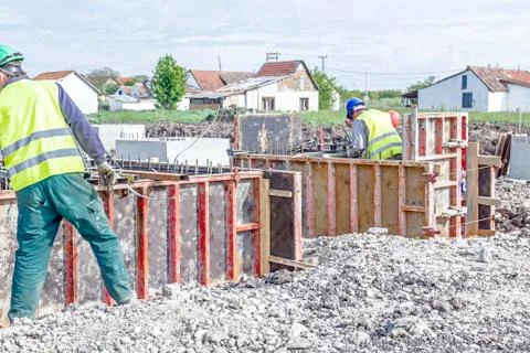 Workers are assembly a mold with reinforcement mesh for concreting Stock Photos