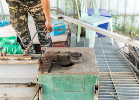 The workers are bending rebar using a rebar bending machine. Foto stock