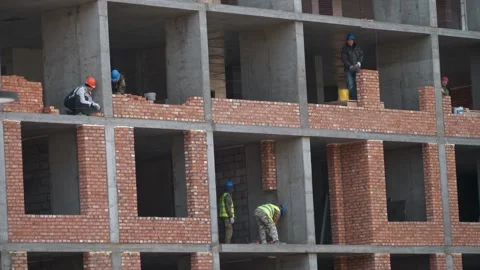 Workers are building a brick wall at different levels. Construction Stock Footage 321004584