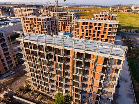 Workers are building a large structure with concrete and bricks in an urban a Stock Photos