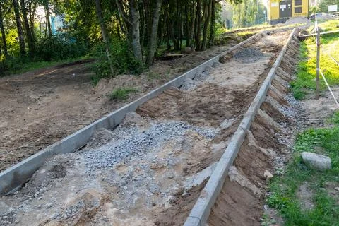 Workers are building a pathway with gravel and concrete in the forest Stock Photos