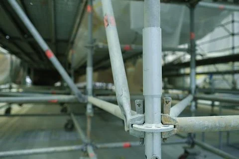 Workers are building a scaffolding structure inside a large facility to support Fotos de archivo
