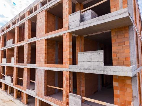 Workers are building a structure with brick walls and concrete slabs. The set Stock Photos