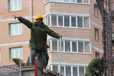 Workers are on building structures, repair the wall of the building. Stock Photos