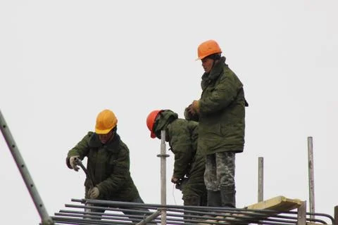 Workers are on building structures, repair the wall of the building. Stock Photos