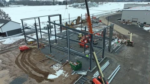 Workers are busy at a construction site in winter. They use cranes and Stock Footage 336116501