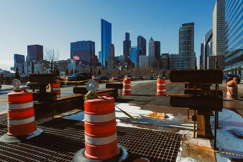 Workers are busy with construction tasks using orange and white barriers in f Фото