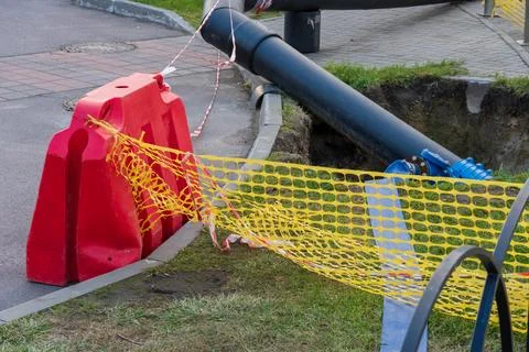 Workers are busy replacing old water pipes on a city street, involving sign.. Stock Photos