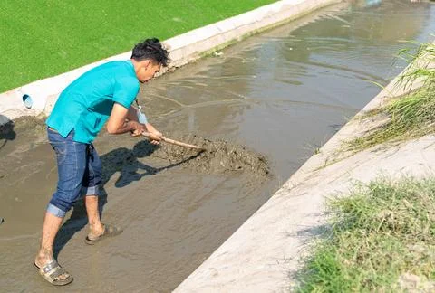 Workers are cleaning the drain with a mop. Stock Photos
