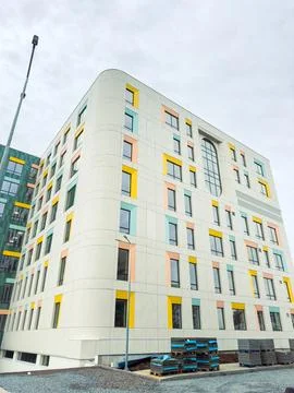 Workers are completing final touches on a new building with bright colors on  Stockfoto's