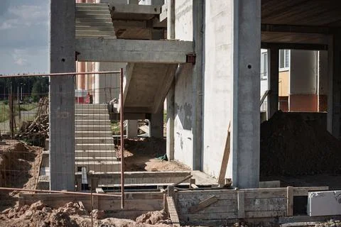 Workers are constructing a building with a concrete staircase visible, showca Stock Photos