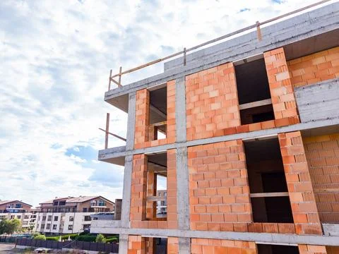 Workers are constructing a building using bricks and concrete in a city. The  Stock Photos