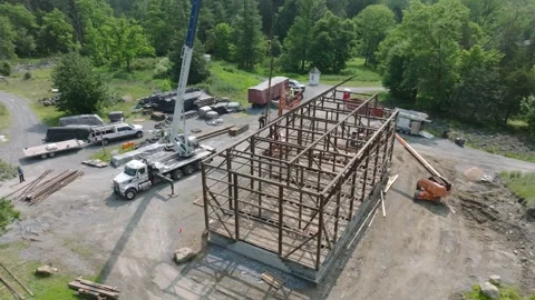 Workers are constructing a large wooden structure in a forest area. Cranes are Stock Footage 331699501