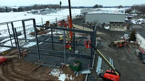 Workers are constructing a new building in winter. Heavy equipment is present Stock Footage 338059916