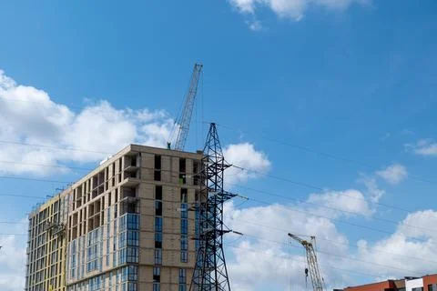 Workers are constructing a new house at a busy site with cranes and scaffol.. Fotos de archivo