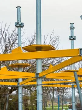 Workers are constructing a playground structure with yellow components in a p Stock Photos