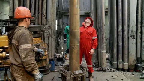 Workers are controlling the drill pipe  immersion inside an oil drilling rig. Stock Footage 256692664