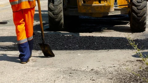 Workers are dragging the asphalt into the pit Stock-Footage 87956057