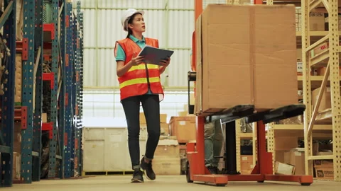 Workers are dragging trolleys to arrange goods in a large warehouse. Stock Footage 142754080