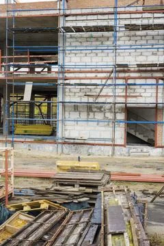 Workers are engaged in building a structure with scaffolding and various mate 스톡 사진