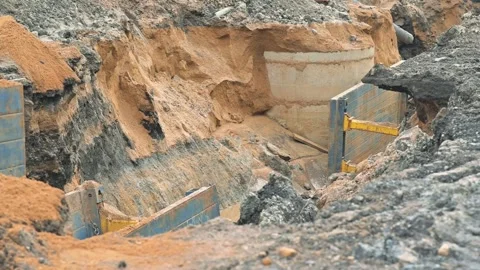 Workers are engaged in excavation at a construction site, where soil is being Vidéo 344675231