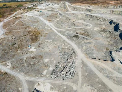 Workers are extracting granite in a quarry. Heavy machinery is in use, and li Fotos Stock
