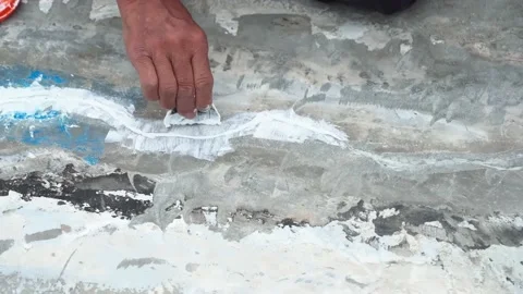 Workers are fixing cracks in the floor, spreading plaster using trowel, Repairin Stock Footage 169442527