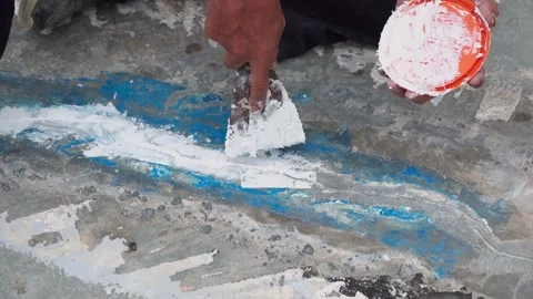 Workers are fixing cracks in the floor, spreading plaster using trowel, Repairin Stock Footage 169442580