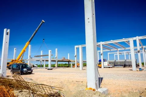 Workers are helping crane to keep balance and direction of concrete joist Stock Photos